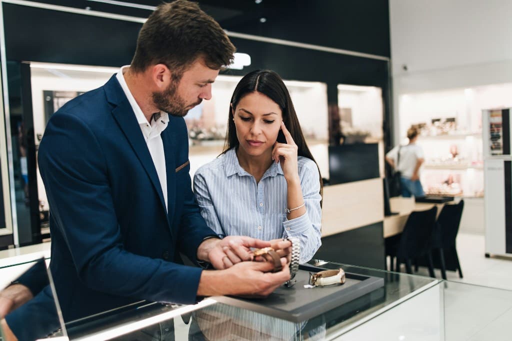Personal concierge presenting a watch to a client in a boutique